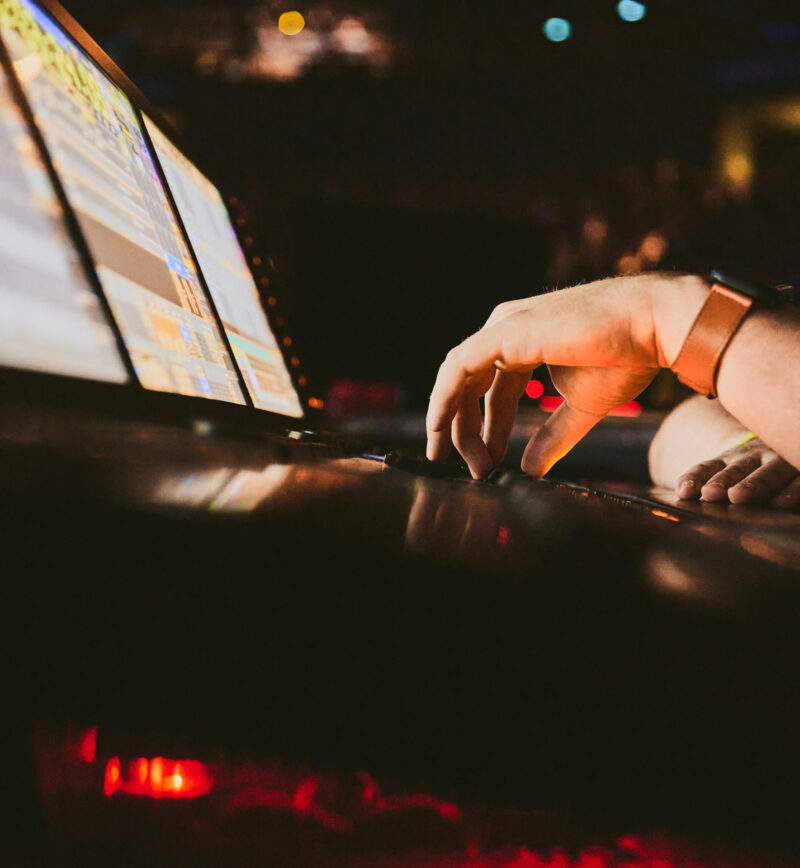 hände am laptop steuern die inbetriebnahme von licht und tontechnik protones